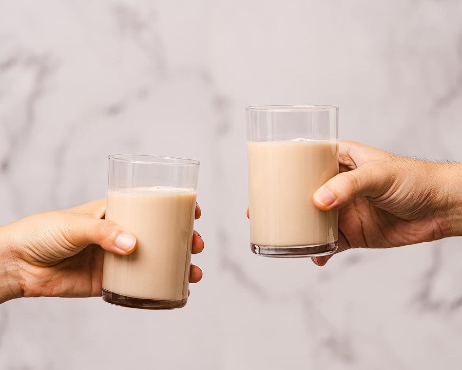 Holding Delicious Beverage Glasses Of Plant Based Bam Nut Milk