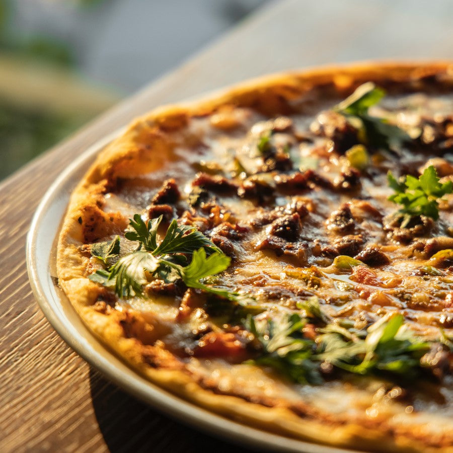 Organic Thin Crust Pizza With Fresh Parsley In The Sunlight